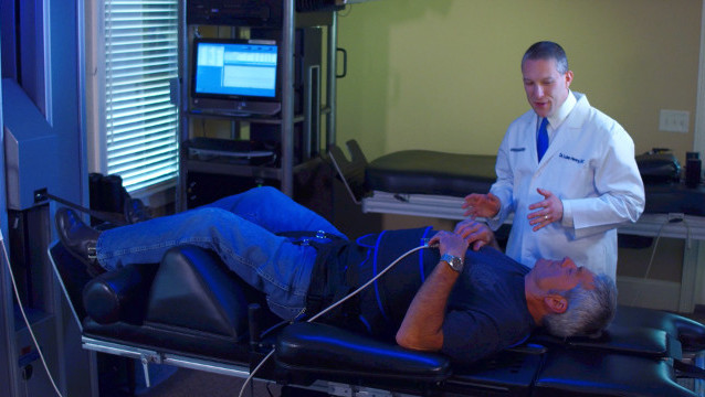 Dr. Henry providing lumbar spinal decompression therapy for lower back pain treatment